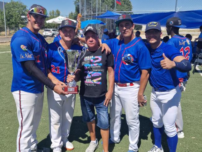 Para de los integrantes del equipo Los Renegados con el trofeo de campeón